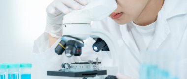 Bilimadamı ileri bilimsel laboratuvarda biyokimyasal örnekleri analiz ediyor. Tıbbi profesyonel kullanım mikroskobu virüsün mikrobiyolojik gelişimini gösteriyor. Fen laboratuvarında biyoteknoloji araştırması.