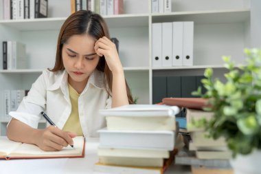 Asian student woman have anxiety because of exams, female prepare for test and learning lessons in the library. stress, despair, haste, misunderstanding reading, discouraged, expectation, knowledge