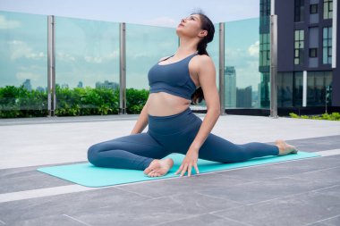 Sıska kadın evinin balkonunda yoga yapıyor. Sabahları egzersiz yapan Asyalı bir kadın. denge, meditasyon, rahatlama, sakinlik, sağlık, mutluluk, rahatlama, sağlıklı yaşam tarzı konsepti