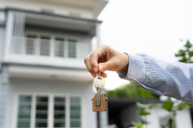 Kira, kiralama ve ev satma. Emlakçının elinde yeni bir ev ya da emlak için anahtar var. kira, satış, kredi finans, sigorta, satıcı, dağıtıcı, taksit, satın alma, satma, taşınma