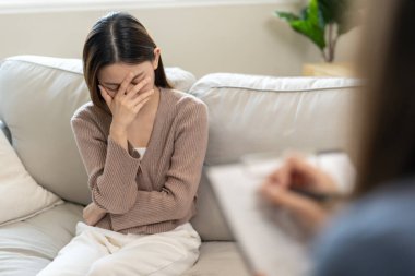 Akıl sağlığı sorunları olan bir kadın danışmanlık yapıyor. Psikiyatrist tedavi için hastanın durumunu kaydediyor. teşvik, sevgi ve aile sorunu, bipolar, depresyon hastası, intiharı koru