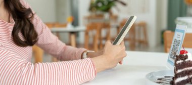 Woman use smartphone to scan QR code to pay in cafe restaurant with a digital payment without cash. Choose menu and order accumulate discount. E wallet, technology, pay online, credit card, bank app.