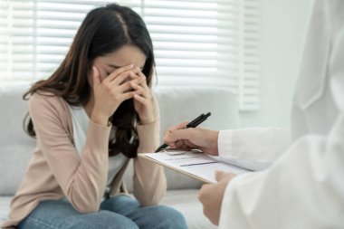 Akıl sağlığı sorunları olan bir kadın danışmanlık yapıyor. Psikiyatrist tedavi için hastanın durumunu kaydediyor. teşvik, sevgi ve aile sorunu, bipolar, depresyon hastası, intiharı koru
