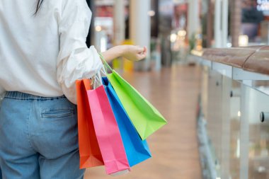 Modern happy asian Female lifestyle fashion portrait. beautiful attractive young woman girl enjoy stylish walk with shopping bag packages use smartphone on the street, trendy outfit on shopping mall