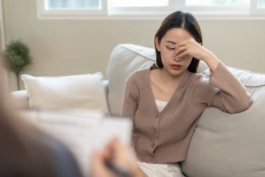 Akıl sağlığı sorunları olan bir kadın danışmanlık yapıyor. Psikiyatrist tedavi için hastanın durumunu kaydediyor. teşvik, sevgi ve aile sorunu, bipolar, depresyon hastası, intiharı koru