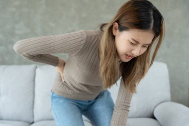 Asya 'da güzel bir kadın belini tutuyor ve dayanılmaz ağrılar çekiyor. Sağlık ve sorunlar, kronik sırt ağrısı, ofis sendromu, skolyoz, bel fıtığı, kas iltihabı.