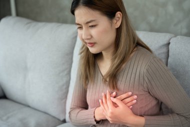 Göğüs kafesinde kalp krizi belirtileri var. Asyalı kadınlarda göğüs ağrısı var. Kalp rahatsızlığı, sızıntı, genişleme, genişlemiş kalp, göğse acı verici bir ifadeyle bastırma.