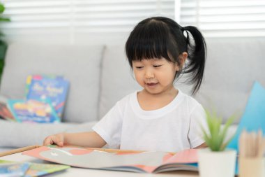 Mutlu Asyalı çocuklar evde kitap okuyarak rahatlar. Kızım ve bir hikaye okuyordum. öğrenme, çocuk bakımı, gülme, eğitim, hikaye anlatma, uygulama, hayal etme, bağımlılık cep telefonunu azaltma