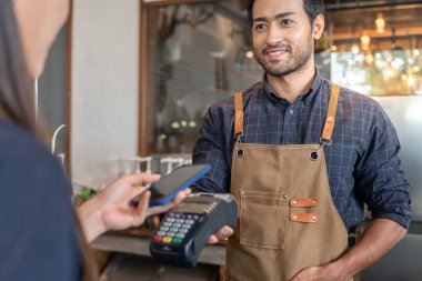 Kafe restoranında nakit olmadan dijital ödemeyle ödeme yapmak için mutlu bir alıcı QR kodu alıyor. Menüyü ve siparişi seçin ve indirimi toplayın. E cüzdan, teknoloji, online ödeme, kredi kartı, banka uygulaması.