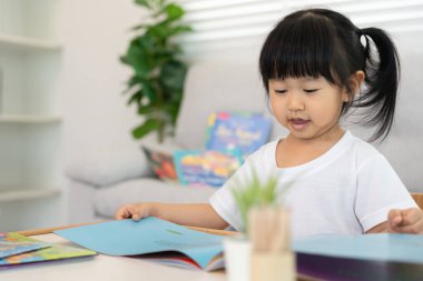 Mutlu Asyalı çocuklar evde kitap okuyarak rahatlar. Kızım ve bir hikaye okuyordum. öğrenme, çocuk bakımı, gülme, eğitim, hikaye anlatma, uygulama, hayal etme, bağımlılık cep telefonunu azaltma