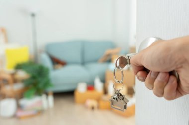 Taşınmak, taşınmak. Yeni dairede adam kapıyı açıyor. Yeni evine taşın. Emlak al ya da kirala. konut kirası, kiralık mülk, yeni ev sahibi, yatırım, konut, kredi, ipotek.