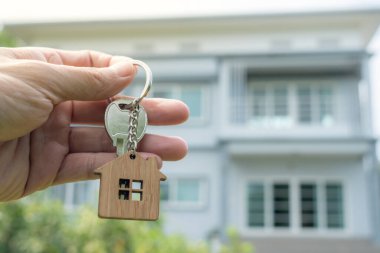 Kira, kiralama ve ev satma. Emlakçının elinde yeni bir ev ya da emlak için anahtar var. kira, satış, kredi finans, sigorta, satıcı, dağıtıcı, taksit, satın alma, satma, taşınma