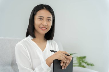 Çalışan kadın portresi, işteki gülümseyen Asyalı kız ve kayıt notu, serbest çalışma, site dışı araştırma, kopya alanı, mutlu neşeli iş, pozitif enerji, iş planı, kadın yönetici