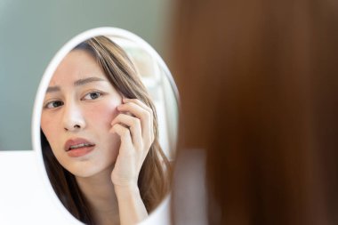 Asyalı kadın yüz dermatolojisi ve kozmetik ürünlerinde steroidlere alerjisi olduğu için endişeli. Hassas cilt, güneş yanığı, sivilce, kimyasallara alerjisi, yüzünde kızarıklık. cilt sorunları ve güzellik