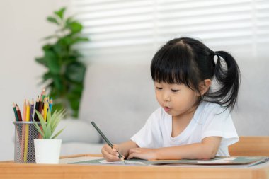 Mutlu Asya çocukları kağıt üzerinde resim yapmayı öğreniyor. Etkinlik, gelişim, IQ, EQ, meditasyon, beyin, kas, temel beceriler, ailenin birlikte zaman geçirmesi. Holida.