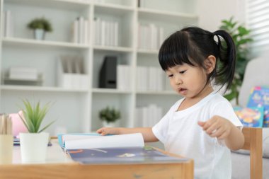 Mutlu Asyalı çocuklar evde kitap okuyarak rahatlar. Kızım ve bir hikaye okuyordum. öğrenme, çocuk bakımı, gülme, eğitim, hikaye anlatma, uygulama, hayal etme, bağımlılık cep telefonunu azaltma