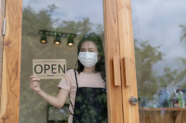 Business man owner show sign open on the first day of business. guarantees safety, cleanliness, open the coffee shop. open for New normal. Small business, welcome, restaurant, home made