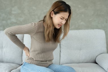 Kadın belini tutuyor ve dayanılmaz ağrılar çekiyor. Sağlık ve sorunlar, kronik sırt ağrısı, ofis sendromu, skolyoz, bel fıtığı, kas iltihabı.