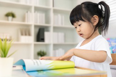 Mutlu Asyalı çocuklar evde kitap okuyarak rahatlar. Kızım ve bir hikaye okuyordum. öğrenme, çocuk bakımı, gülme, eğitim, hikaye anlatma, uygulama, hayal etme, bağımlılık cep telefonunu azaltma