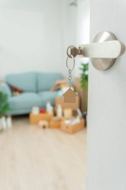 Moving house, relocation. The key was inserted into the door of the new house, inside the room was a cardboard box containing personal belongings and furniture. move in the apartment or condominiu