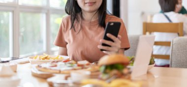 Woman use smartphone to scan QR code to pay in cafe restaurant with a digital payment without cash. Choose menu and order accumulate discount. E wallet, technology, pay online, credit card, bank app.