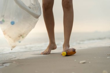 Su tasarrufu. Gönüllü olarak plajdaki çöpleri topluyor ve plastik şişeler suda yaşayan canlılara zarar gelmesini engelliyor. Dünya, Çevre, Yeşilci Gezegen, küresel ısınmayı azaltmak, Dünya 'yı kurtarmak