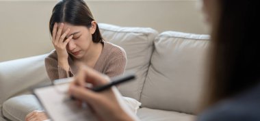 Akıl sağlığı sorunları olan bir kadın danışmanlık yapıyor. Psikiyatrist tedavi için hastanın durumunu kaydediyor. teşvik, sevgi ve aile sorunu, bipolar, depresyon hastası, intiharı koru