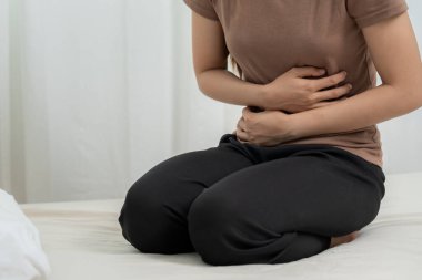 stomach ache. Asian women have abdominal pain, indigestion, gastritis, menstrual cramps, flatulence, diarrhea, distention, colon cancer, belly inflammation problem, suffer food poisoning, abdomen