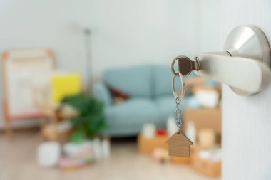 Moving house, relocation. The key was inserted into the door of the new house, inside the room was a cardboard box containing personal belongings and furniture. move in the apartment or condominium