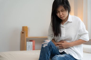 stomach ache. Asian women have abdominal pain, indigestion, gastritis, menstrual cramps, flatulence, diarrhea, distention, colon cancer, belly inflammation problem, suffer food poisoning, abdomen