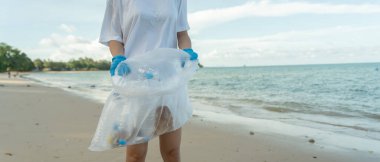 Okyanusu kurtar. Gönüllü olarak plajdaki çöpleri topluyor ve plastik şişeler suda yaşayan canlılara zarar gelmesini engelliyor. Dünya, Çevre, Yeşilci Gezegen, küresel ısınmayı azaltmak, Dünya 'yı kurtarmak