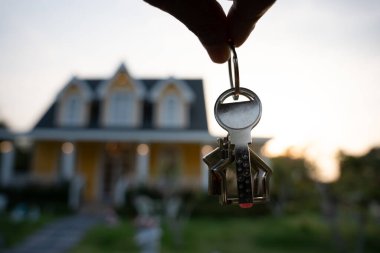 Kira, kiralama ve ev satma. Emlakçının elinde yeni sahibinin anahtarı var. kira, satış, kredi finans, sigorta, satıcı, dağıtıcı, taksit, satın alma, satma, taşınma