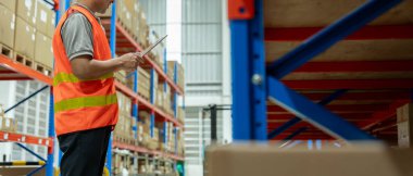 Asya 'daki erkek fabrika envanterini inceleyip kontrol ediyor, stok ürünlerini sayıyor. Lojistik ticaret nakliyesi, müşterilere teslimat. Denetleme, depo, depolama, fabrika, yönetme