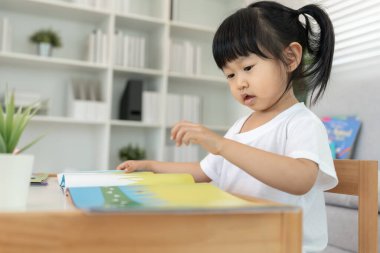 Mutlu Asyalı çocuklar evde kitap okuyarak rahatlar. Kızım ve bir hikaye okuyordum. öğrenme, çocuk bakımı, gülme, eğitim, hikaye anlatma, uygulama, hayal etme, bağımlılık cep telefonunu azaltma