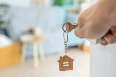 Moving house, relocation. The key was inserted into the door of the new house, inside the room was a cardboard box containing personal belongings and furniture. move in the apartment or condominium