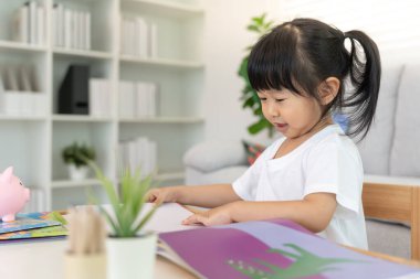 Mutlu Asyalı çocuklar evde kitap okuyarak rahatlar. Kızım ve bir hikaye okuyordum. öğrenme, çocuk bakımı, gülme, eğitim, hikaye anlatma, uygulama, hayal etme, bağımlılık cep telefonunu azaltma