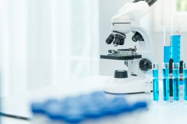 Bilimadamı ileri bilimsel laboratuvarda biyokimyasal örnekleri analiz ediyor. Tıbbi profesyonel kullanım mikroskobu virüsün mikrobiyolojik gelişimini gösteriyor. Fen laboratuvarında biyoteknoloji araştırması