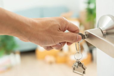 Taşınmak, taşınmak. Anahtar yeni evin kapısına yerleştirilmiş, odanın içinde kişisel eşyalar ve mobilyalar içeren bir karton kutu vardı. Daireye gir, afiş.