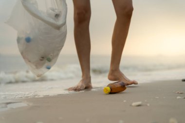 Okyanusu kurtar. Gönüllü olarak plajdaki çöpleri topluyor ve plastik şişeler suda yaşayan canlılara zarar gelmesini engelliyor. Dünya, Çevre, Yeşilci Gezegen, küresel ısınmayı azaltın, Dünya 'yı Kurtarın