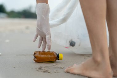 Su tasarrufu. Gönüllü olarak plajdaki çöpleri topluyor ve plastik şişeler suda yaşayan canlılara zarar gelmesini engelliyor. Dünya, Çevre, Yeşilci Gezegen, küresel ısınmayı azaltmak, Dünya 'yı kurtarmak
