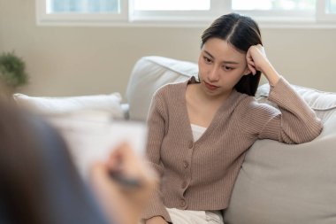 Akıl sağlığı sorunları olan bir kadın danışmanlık yapıyor. Psikiyatrist tedavi için hastanın durumunu kaydediyor. teşvik, sevgi ve aile sorunu, bipolar, depresyon hastası, intiharı koru