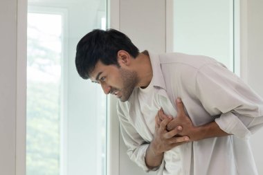 Göğüs kafesinde kalp krizi belirtileri var. Asyalı bir adamın göğüs ağrısı var. Kalp hastalığından, sızıntıdan, genişlemeden, genişlemiş kalp krizinden, göğsüne acı veren bir ifadeyle bastırılmış.