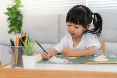 Mutlu Asya çocukları kağıt üzerinde resim yapmayı öğreniyor. Etkinlik, gelişim, IQ, EQ, meditasyon, beyin, kas, temel beceriler, ailenin birlikte zaman geçirmesi. Holida.