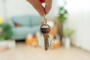 Moving house, relocation. Man hold key house keychain in new apartment. move in new home. Buy or rent real estate. flat tenancy, leasehold property, new landlord, investment, dwelling, loan, mortgage.