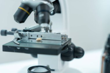 Bilimadamı ileri bilimsel laboratuvarda biyokimyasal örnekleri analiz ediyor. Tıbbi profesyonel kullanım mikroskobu virüsün mikrobiyolojik gelişimini gösteriyor. Fen laboratuvarında biyoteknoloji araştırması.