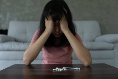 Asyalı kadın aşırı dozda hap kullanıyor, stresli, üzgün, uyuşturucu bağımlısı, hasta, sağlıksız, mutsuz, intihar, depresyon veya ümitsiz, uyuşturucu bağımlısı, yaşam ve aile sorunları, motivasyonsuz
