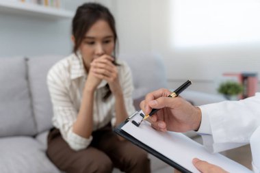 Akıl sağlığı sorunları olan bir kadın danışmanlık yapıyor. Psikiyatrist tedavi için hastanın durumunu kaydediyor. teşvik, sevgi ve aile sorunu, bipolar, depresyon hastası, intiharı koru