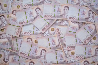 Tayland para birimi, çok sayıda THAI banknotları masaya yerleştirilmiştir. Baht, Tayland borsasını değiştirmek, satın almak, satmak, biriktirmek ve yatırım yapmak için kullanılan para birimidir.