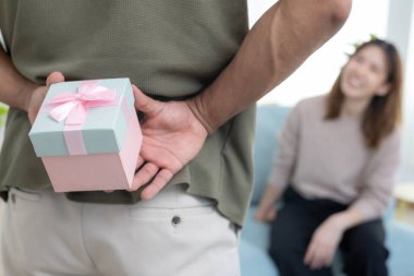 Mutlu koca sürpriz eş için hediye kutusu arar ve saklar. Sevimli kız, heyecanlı hediye kutusu. Doğum günü, kutlama, xmas, yeni yıl festivali, teşekkür, kutlama, sevgililer günü, evlilik yıldönümü 