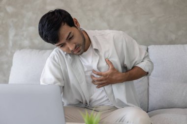 Göğüs kafesinde kalp krizi belirtileri var. Çok çalışan bir adamın göğüs ağrısı var. Kalp rahatsızlığı, sızıntı, genişleme, genişlemiş kalp, göğse acı verici bir ifadeyle bastırma.